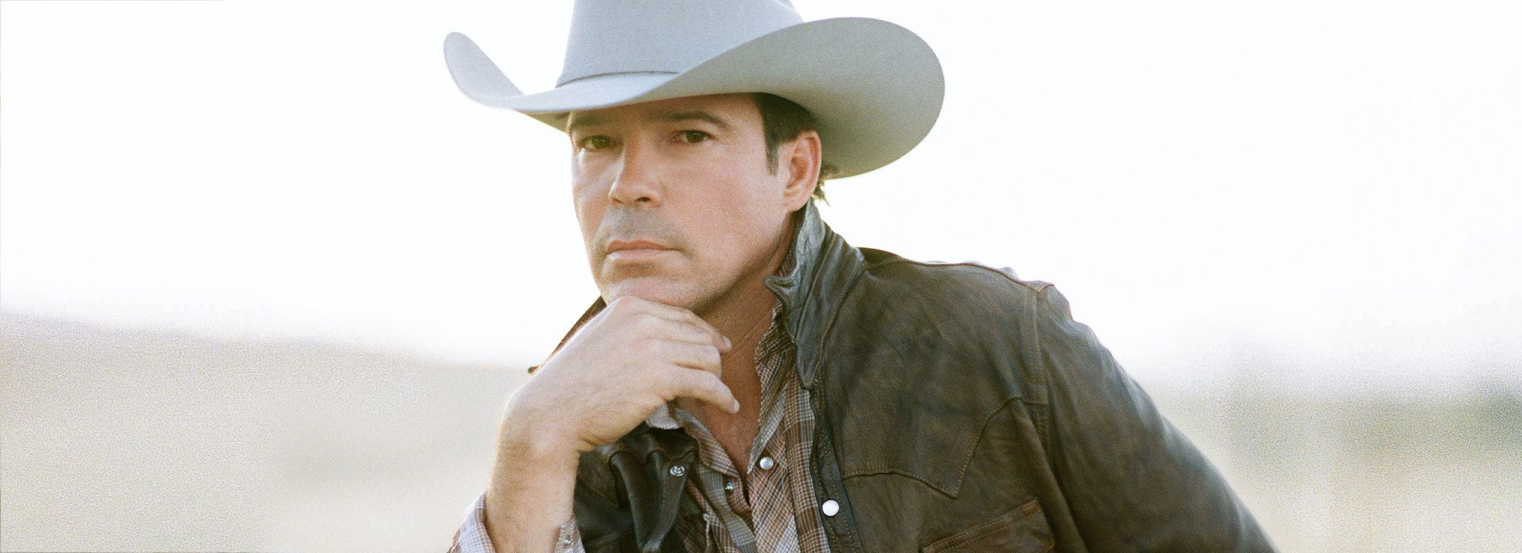 Clay Walker looking into the camera lens while wearing a cowboy hat