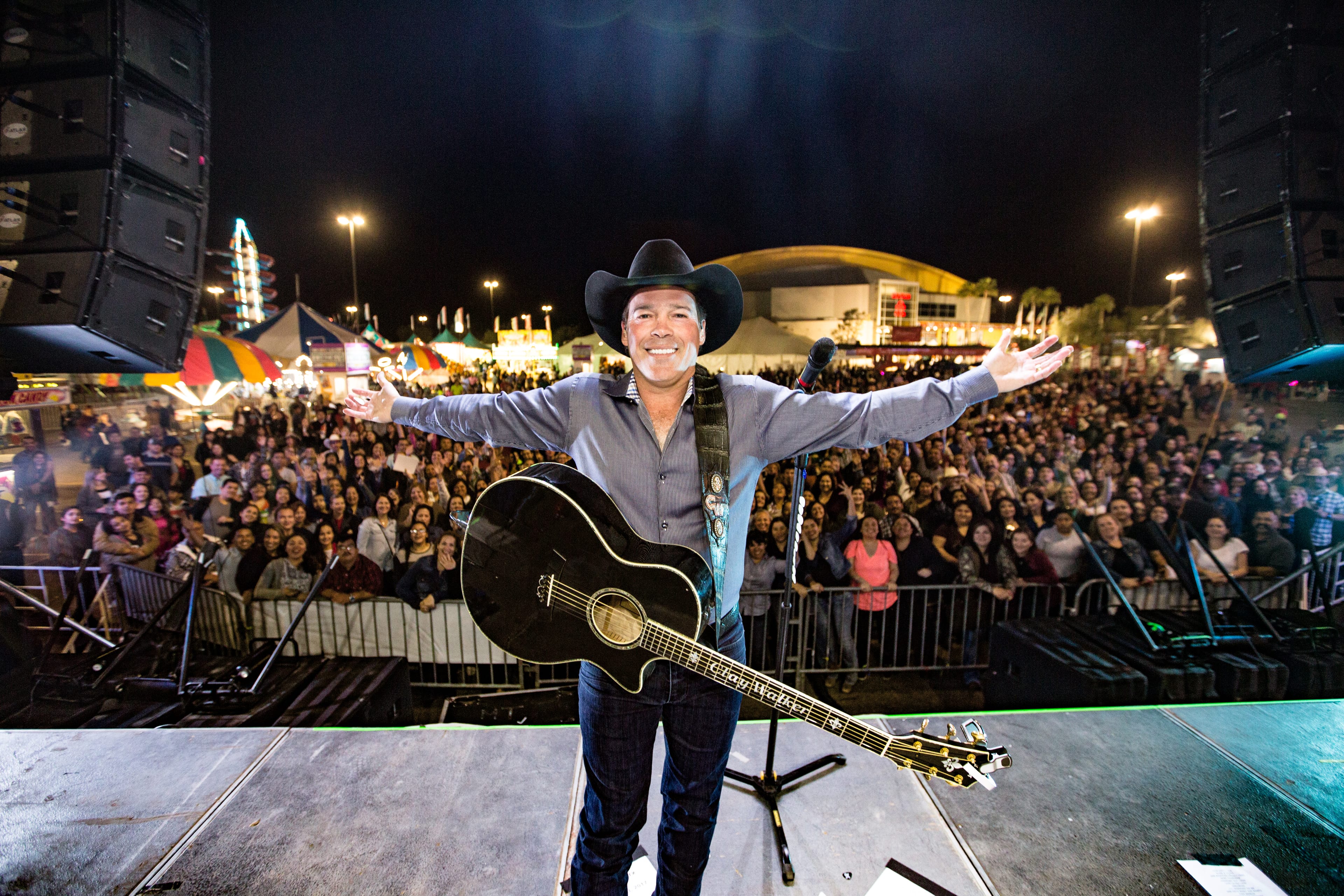 Clay Walker on stage taking a selfie with fans in the background